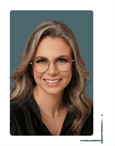 Fotografia colorida da Vanessa, uma mulher com pele branca, cabelo castanho claro longo e ondulado, olhos castanhos e óculos. Ela está sorrindo e veste uma camisa preta.
